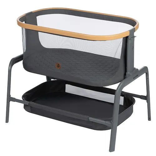 A modern bassinet with a mesh side, wooden trim, and a lower storage tray in a gray and black design.