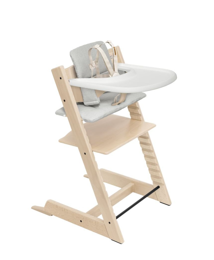 Stokke Tripp Trapp High Chair in natural wood with a white tray and soft gray infant seat.
