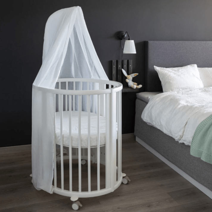 Compact Stokke Sleepi Mini crib with canopy in a modern Canadian bedroom for newborn sleep safety.